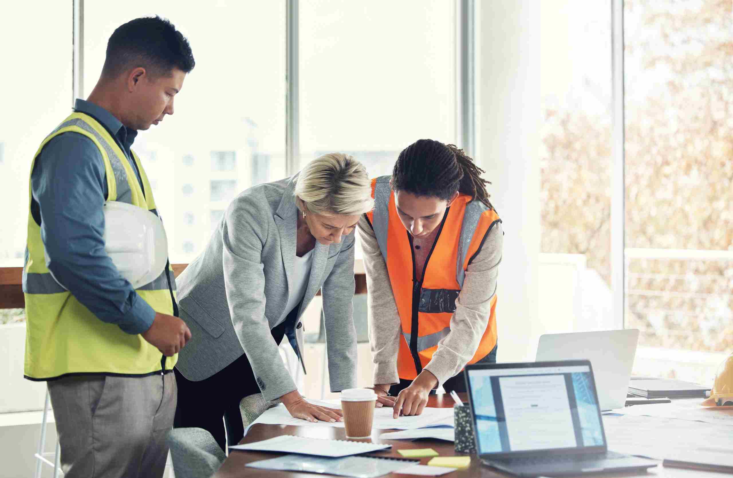 Construction workers reviewing construction reports on a desk